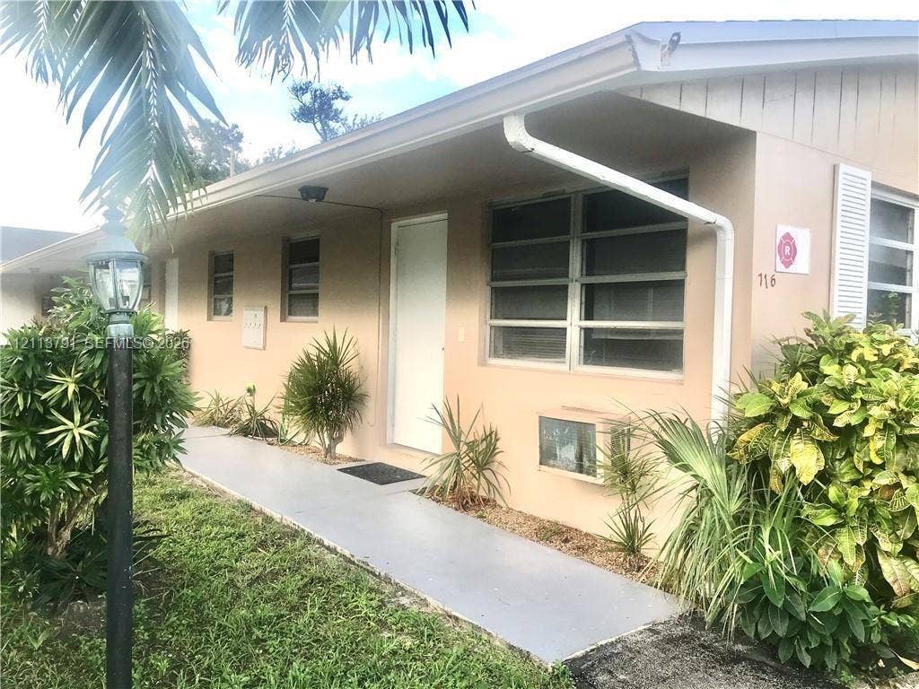 716 SE 18th Street, #1, Fort Lauderdale, Fort Lauderdale, FL 33316 Stucco exterior featuring horizontal louvered windows, a covered concrete walkway, and an integrated exterior light post