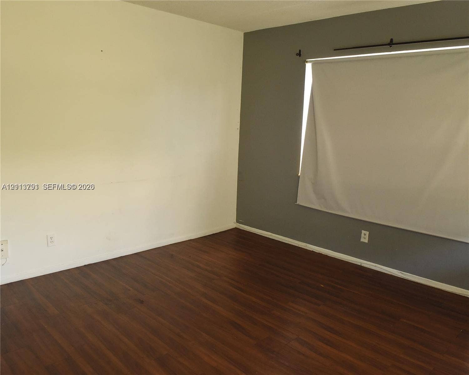 716 SE 18th Street, #1, Fort Lauderdale, Fort Lauderdale, FL 33316 Room featuring dark wood-finish flooring, two-toned wall paint, and a horizontal window with a fitted roller shade