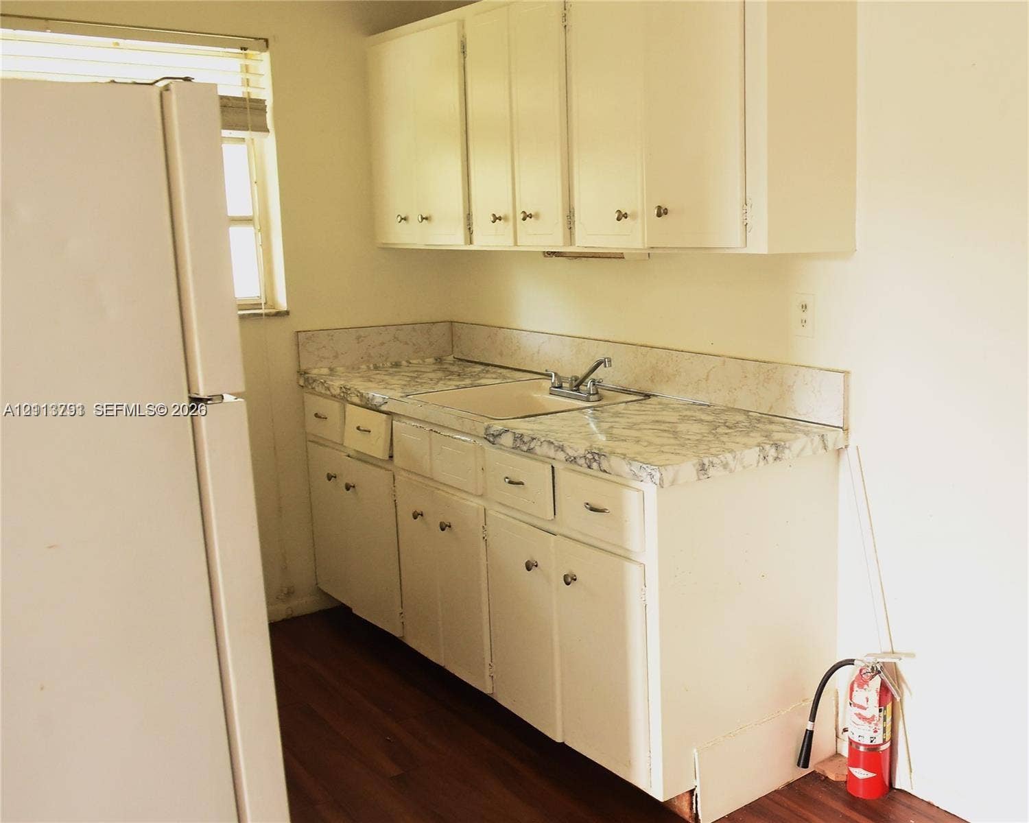 716 SE 18th Street, #1, Fort Lauderdale, Fort Lauderdale, FL 33316 Kitchen featuring white cabinetry, patterned laminate countertops, a dual-basin sink with a metallic faucet, and wood-finish flooring