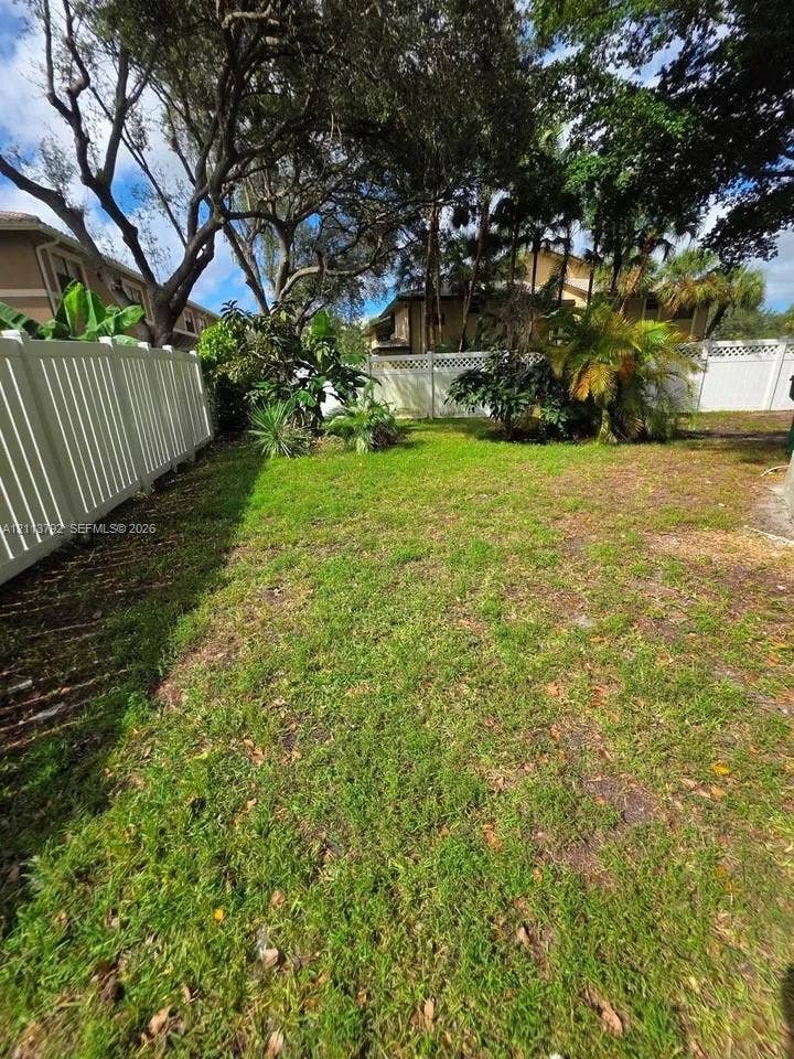 11530 NW 43rd, #1, Coral Springs, Coral Springs, FL 33065 Backyard featuring a grass lawn, perimeter vinyl fencing, and mature trees