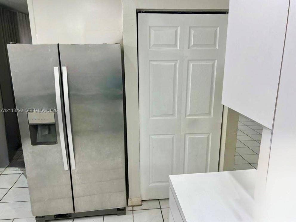 11530 NW 43rd, #1, Coral Springs, Coral Springs, FL 33065 Stainless steel side-by-side refrigerator with exterior water and ice dispenser, complemented by white cabinetry and white tile flooring