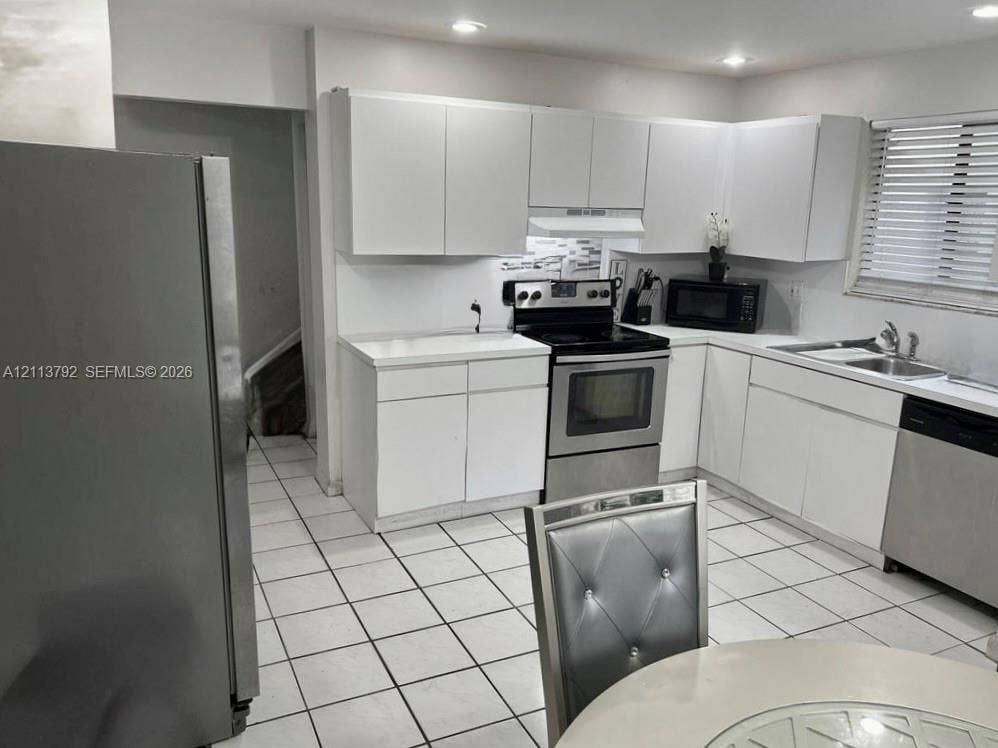 11530 NW 43rd, #1, Coral Springs, Coral Springs, FL 33065 Kitchen featuring flat-panel white cabinetry, solid surface countertops, stainless steel appliances, ceramic tile flooring, and recessed lighting