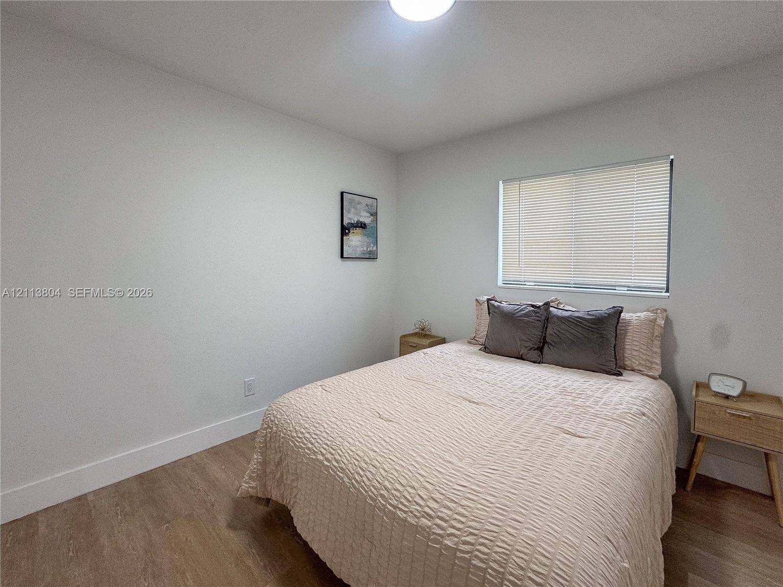2300 NW 31st Avenue, Fort Lauderdale, FL 33311 Neutral-toned interior space featuring wood-finish flooring, white walls, and a window with horizontal blinds