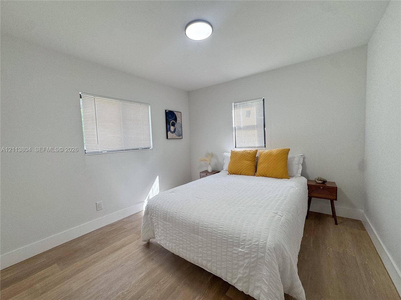 2300 NW 31st Avenue, Fort Lauderdale, FL 33311 Neutral interior featuring wood-finish flooring, white walls, flush-mount lighting, and dual windows with fitted blinds