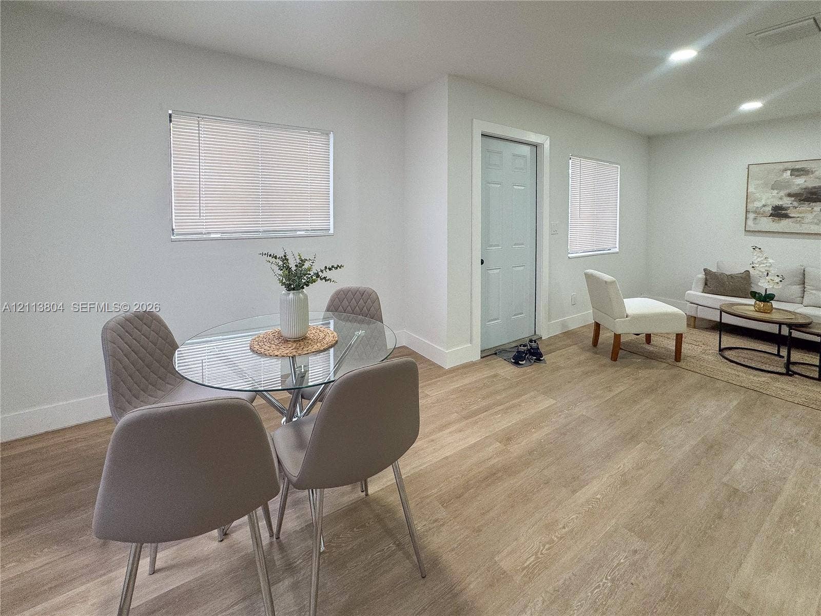 2300 NW 31st Avenue, Fort Lauderdale, FL 33311 Open-concept interior featuring light wood-finish flooring, recessed lighting, neutral wall paint, and multiple windows with horizontal blinds