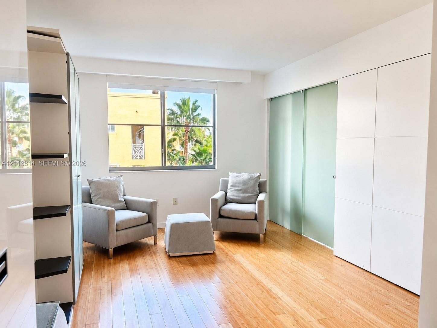 110 Washington Avenue, #1517, Miami Beach, Miami Beach, FL 33139 Wood-finish flooring, floor-to-ceiling built-in white cabinetry, and sliding opaque glass-panel doors