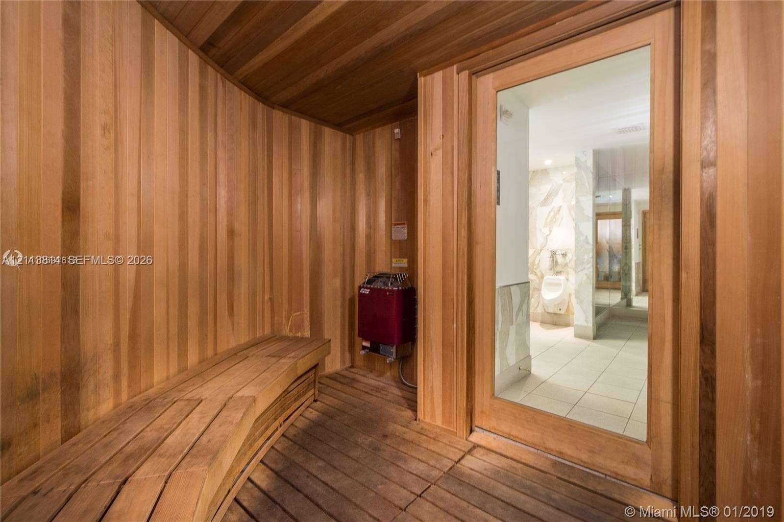 110 Washington Avenue, #1517, Miami Beach, Miami Beach, FL 33139 Sauna featuring wood-plank walls, built-in wooden bench seating, slatted wood flooring, and a glass-panel door