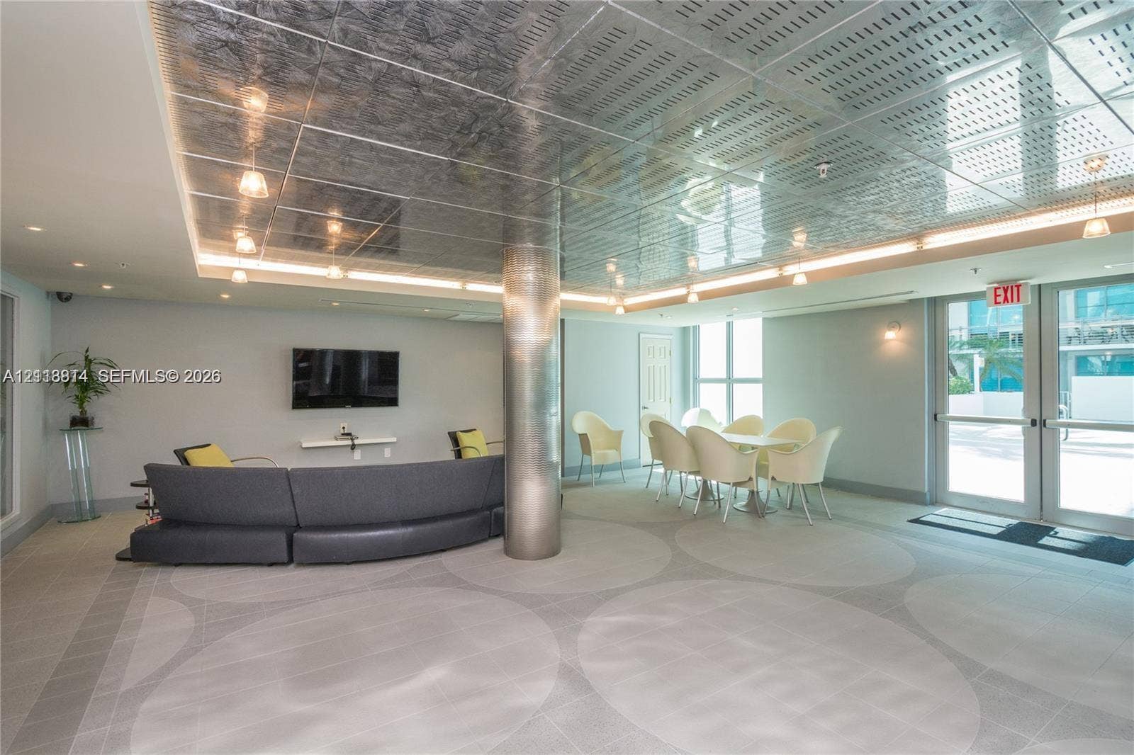 110 Washington Avenue, #1517, Miami Beach, Miami Beach, FL 33139 Metallic paneled ceiling with integrated cove lighting, central metallic support column, patterned tile flooring, and glass-paned double entry doors