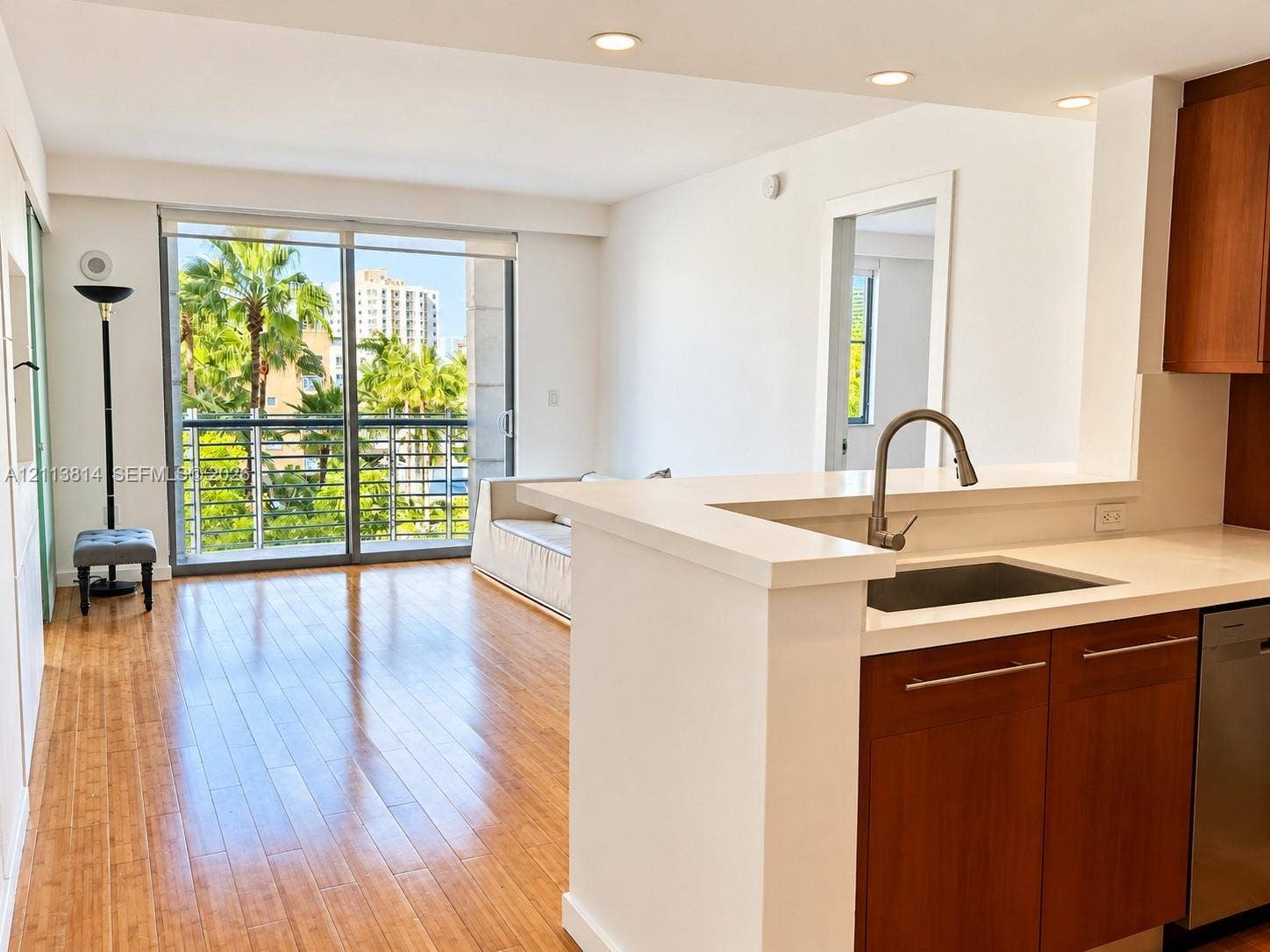 110 Washington Avenue, #1517, Miami Beach, Miami Beach, FL 33139 Kitchen featuring a breakfast bar with stone countertops, an undermount sink with a gooseneck faucet, wood-finish cabinetry, recessed lighting, and wood-finish flooring