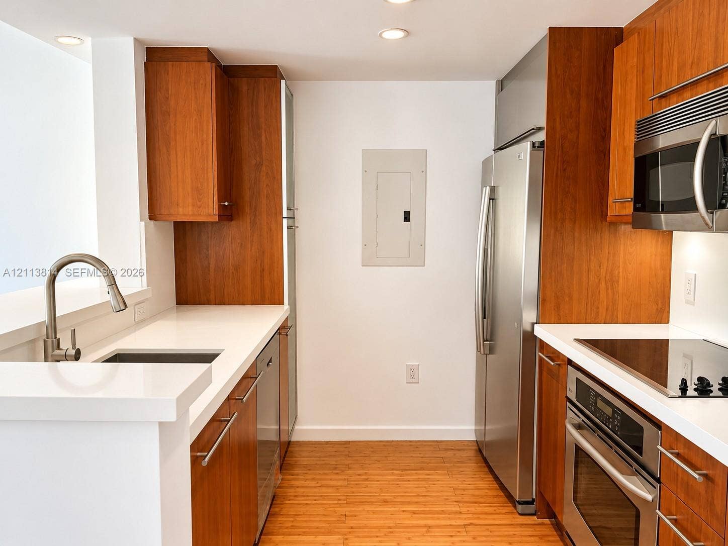 110 Washington Avenue, #1517, Miami Beach, Miami Beach, FL 33139 Kitchen featuring custom wood-finish cabinetry, solid surface countertops, stainless steel appliances, and wood-finish flooring