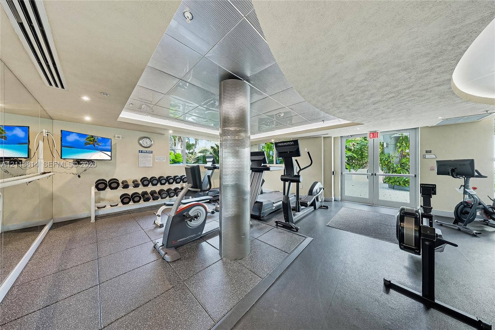 110 Washington Avenue, #1517, Miami Beach, Miami Beach, FL 33139 Fitness center featuring large-format textured tile flooring, mirrored walls, and a recessed ceiling panel with metallic finish