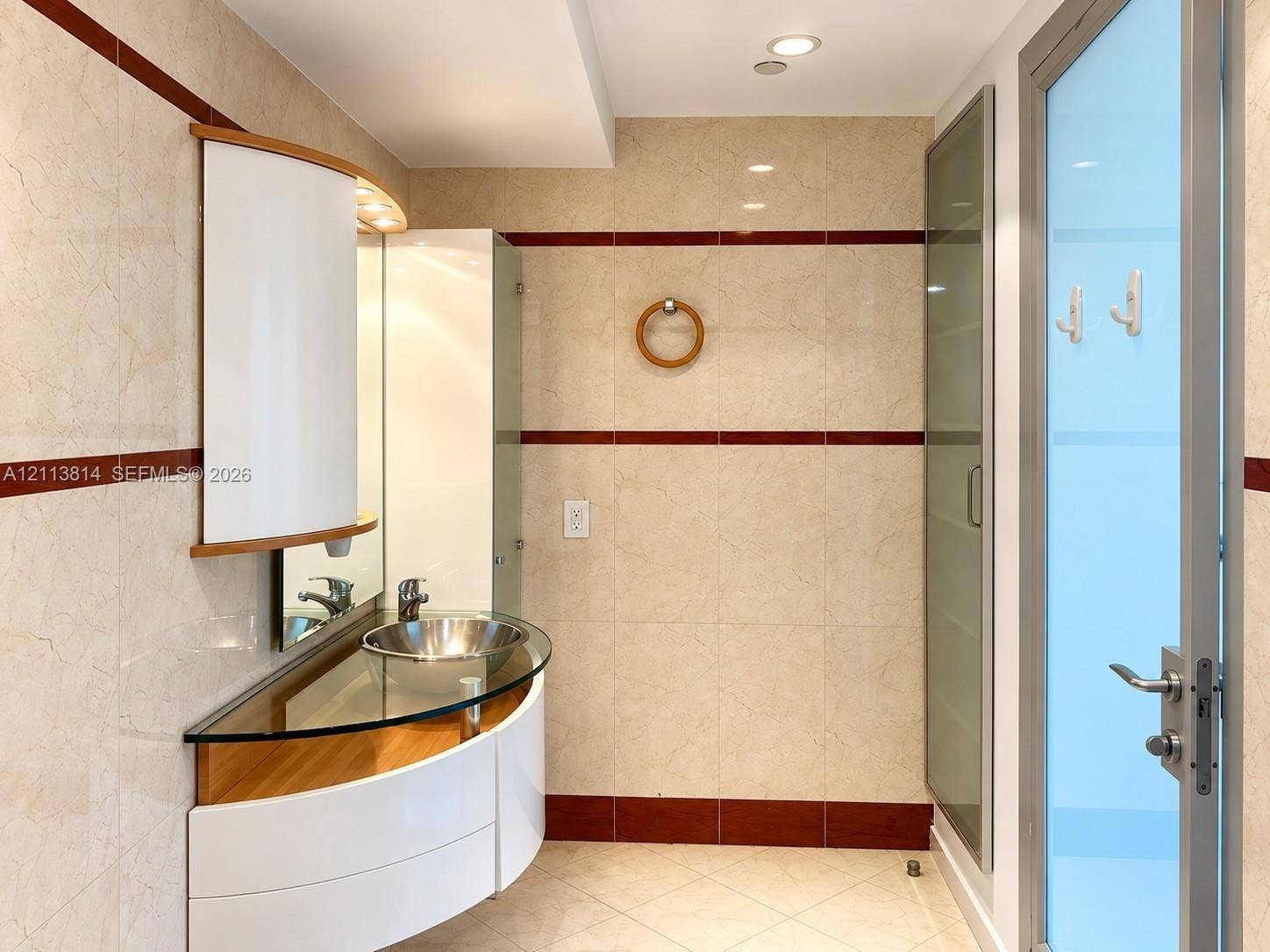 110 Washington Avenue, #1517, Miami Beach, Miami Beach, FL 33139 Curved floating vanity featuring a glass countertop, metallic vessel sink, and white cabinet storage, finished with full-height tile walls and recessed lighting