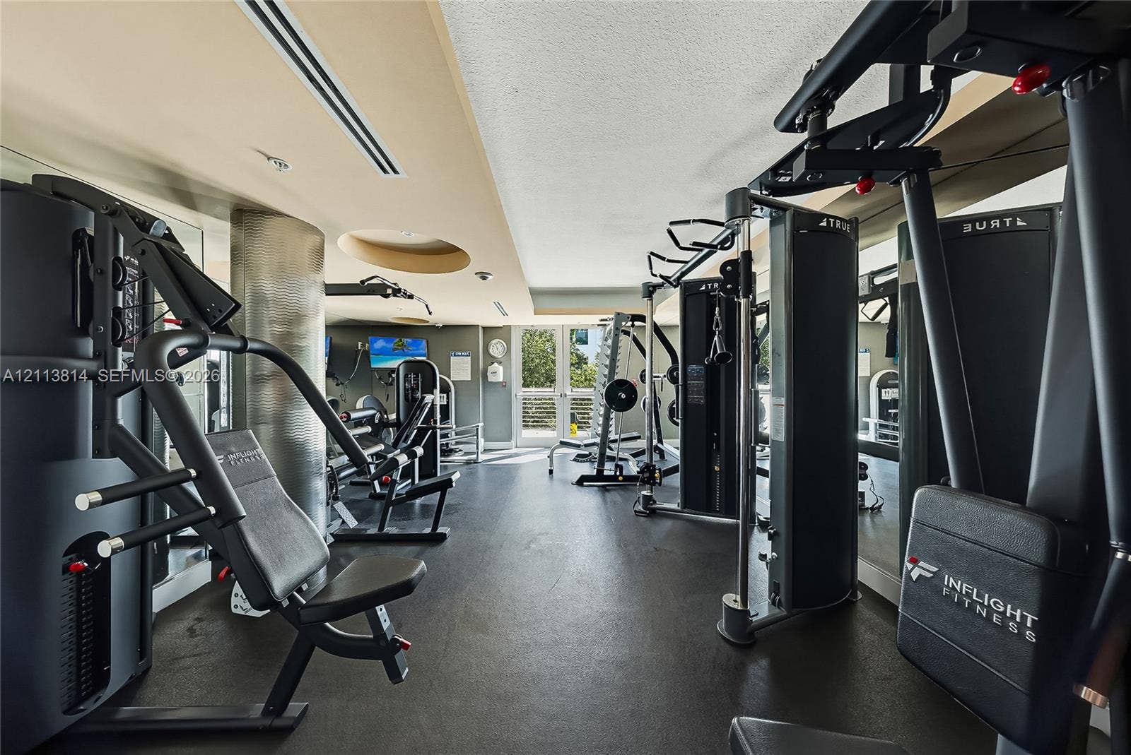 110 Washington Avenue, #1517, Miami Beach, Miami Beach, FL 33139 Fitness center featuring recessed ceiling lighting, a metallic cylindrical structural column, high-contrast wall finishes, and exterior-facing glass doors