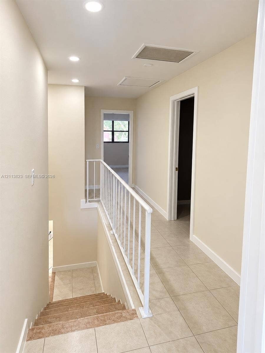 61 Matador Lane, #4-26, Davie, Davie, FL 33324 Neutral tile flooring, white metal railing, and recessed ceiling lighting