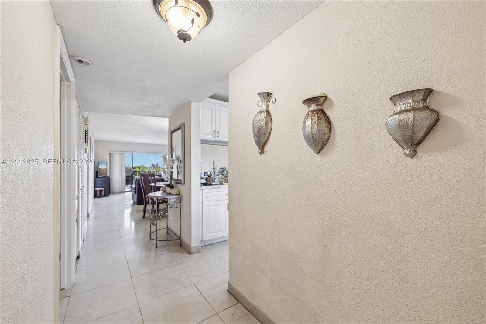 1200 NW 80th Avenue, #405A, Margate, FL 33063 Neutral-toned interior featuring oversized tile flooring, semi-flush mount ceiling lighting, and crisp white cabinetry