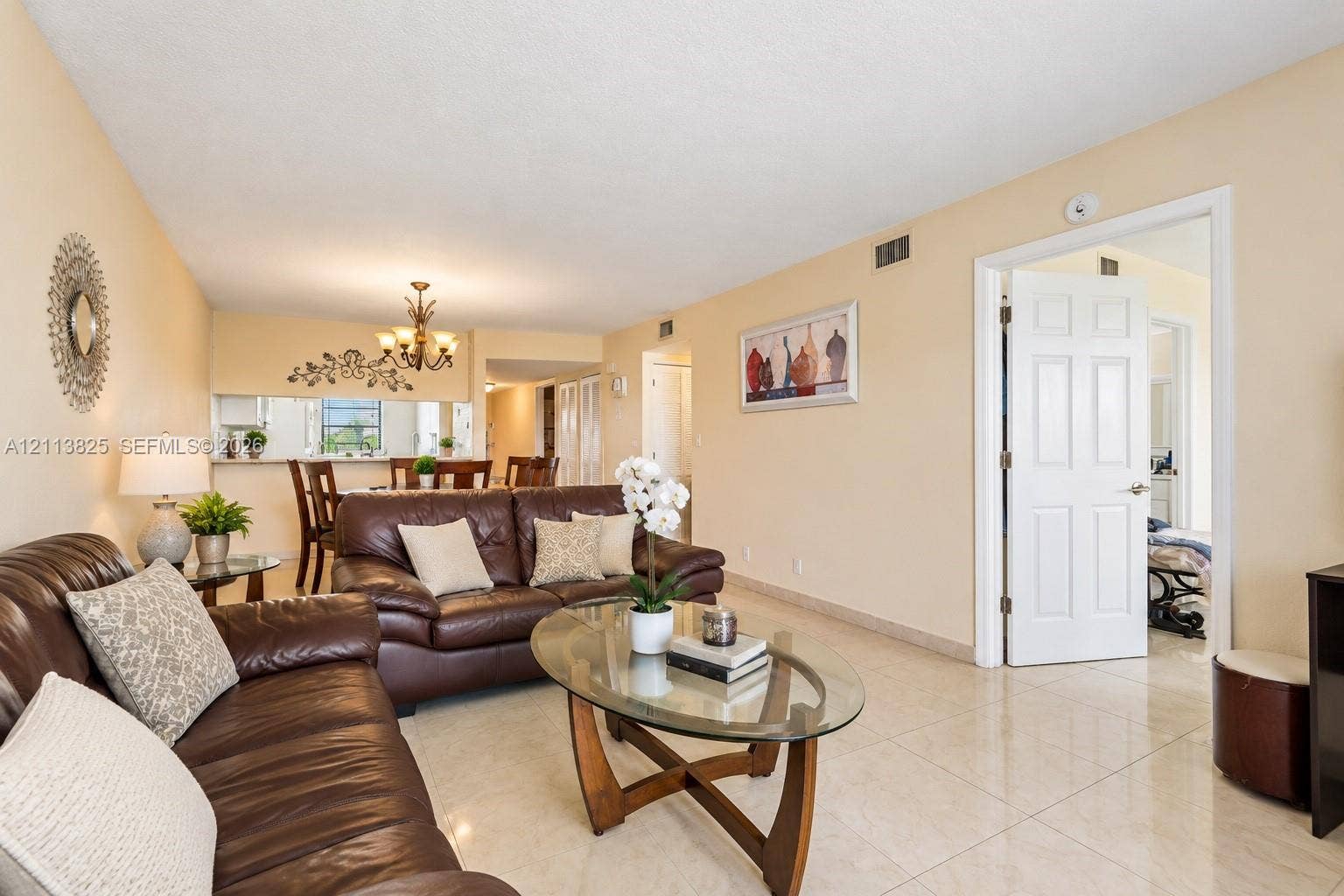 1200 NW 80th Avenue, #405A, Margate, FL 33063 Neutral-toned interior featuring large-format tile flooring, a six-panel interior door, and a multi-arm chandelier