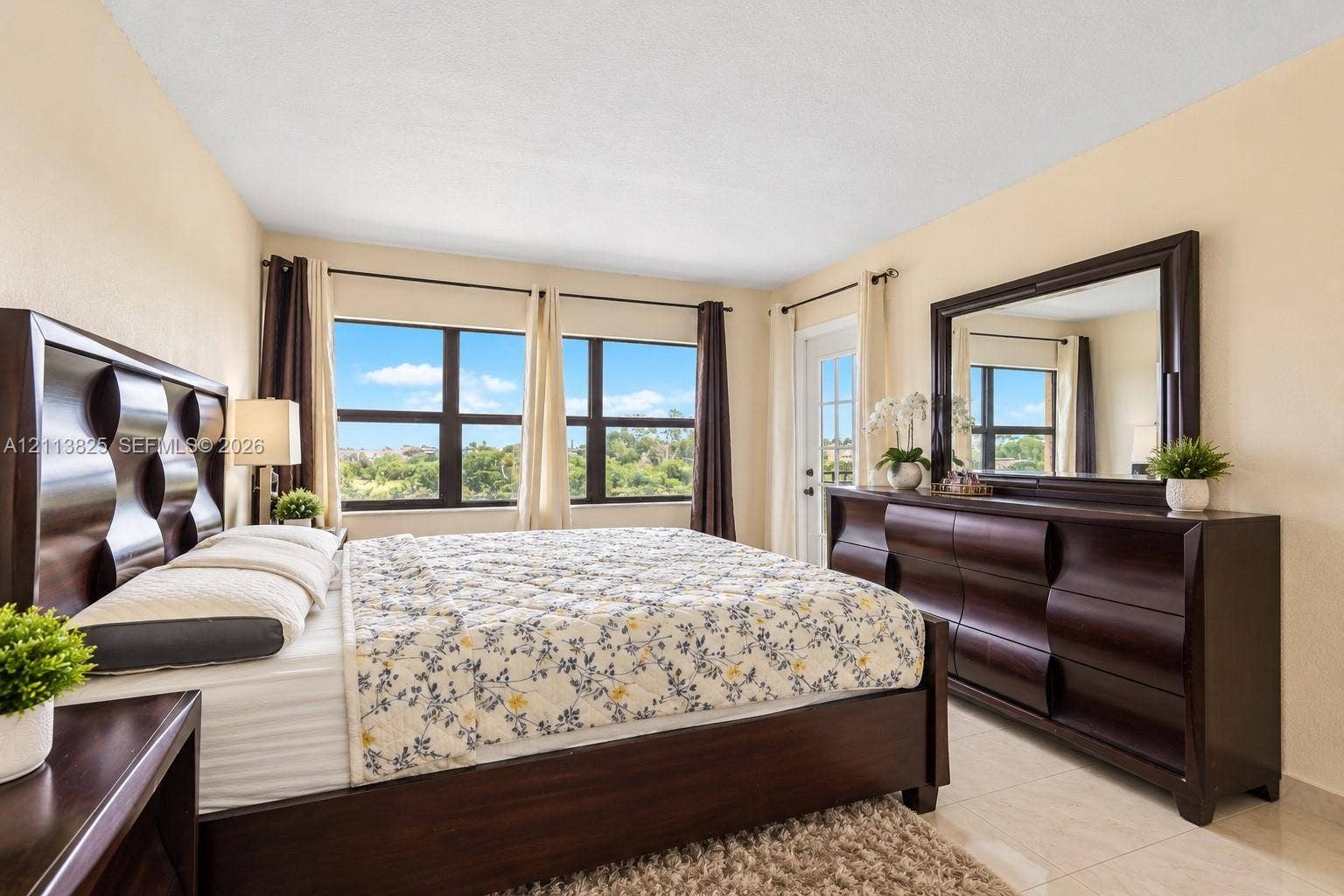1200 NW 80th Avenue, #405A, Margate, FL 33063 Neutral-toned interior featuring expansive multi-pane windows, light-colored tile flooring, and a glass-paneled exterior door
