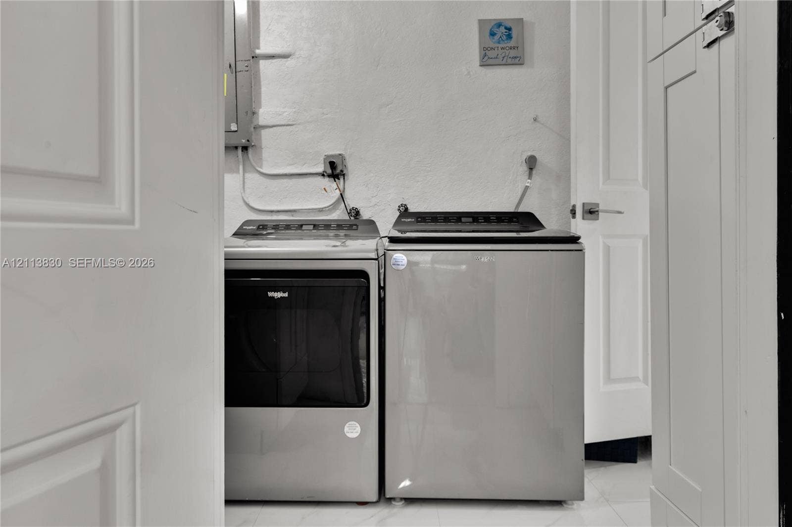 3545 SW 104th Court, Miami, FL 33165 Dedicated utility area featuring panel-style interior doors, light-toned tile flooring, and built-in cabinetry