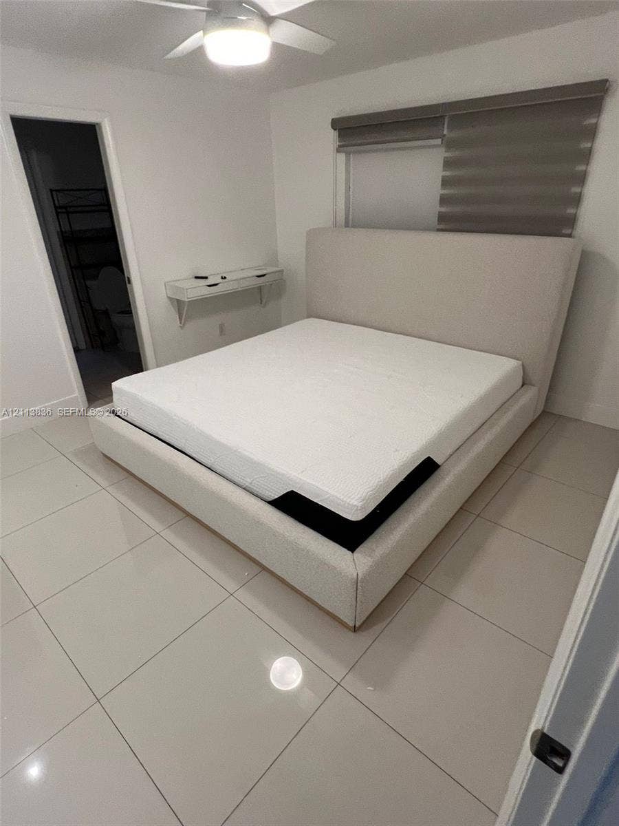 10153 SW 51st Street, Cooper City, Cooper City, FL 33328 Neutral-toned tile flooring, wall-mounted floating shelf, and ceiling-mounted light fixture with an integrated fan