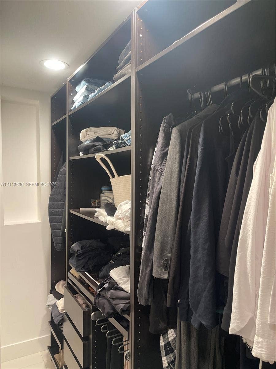 10153 SW 51st Street, Cooper City, Cooper City, FL 33328 Custom-built closet system featuring dark wood-finish shelving, integrated drawers, recessed lighting, and metal hanging rods