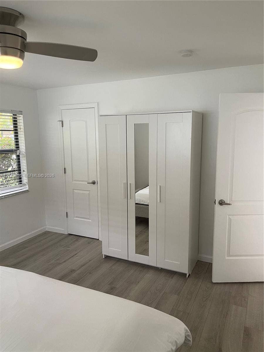 10153 SW 51st Street, Cooper City, Cooper City, FL 33328 Neutral-toned wood-finish flooring, brushed nickel ceiling fan with integrated lighting, and two-panel interior doors with lever-style hardware