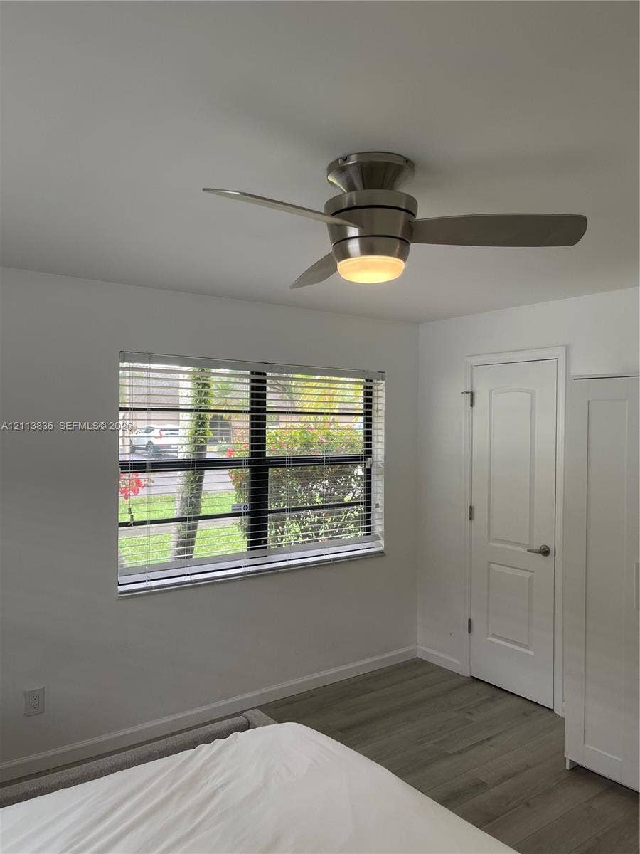10153 SW 51st Street, Cooper City, Cooper City, FL 33328 Flush-mount brushed nickel ceiling fan with integrated lighting, wood-finish flooring, and single-hung window with horizontal blinds