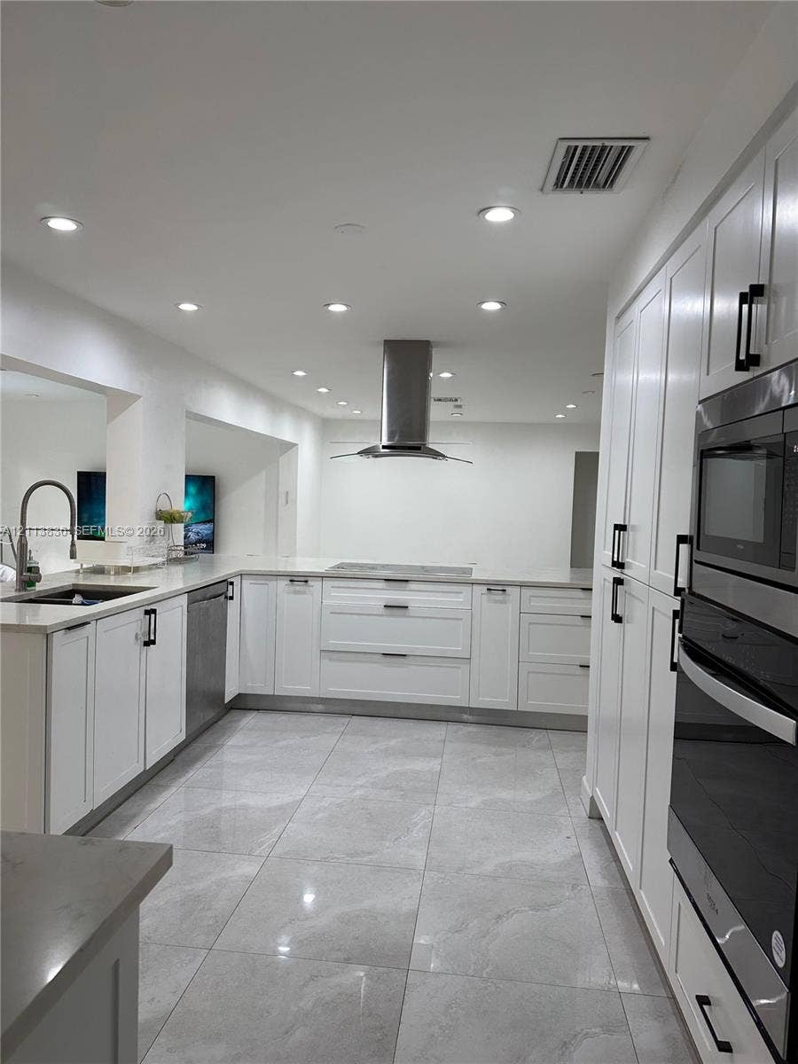 10153 SW 51st Street, Cooper City, Cooper City, FL 33328 Kitchen featuring white shaker-style cabinetry, stainless steel range hood, built-in double oven, stone-finish countertops, and large-format tile flooring
