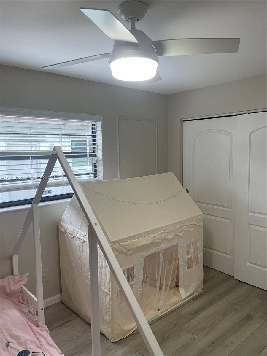 10153 SW 51st Street, Cooper City, Cooper City, FL 33328 Wood-finish flooring, ceiling fan with integrated LED lighting, horizontal window blinds, and dual-panel closet doors