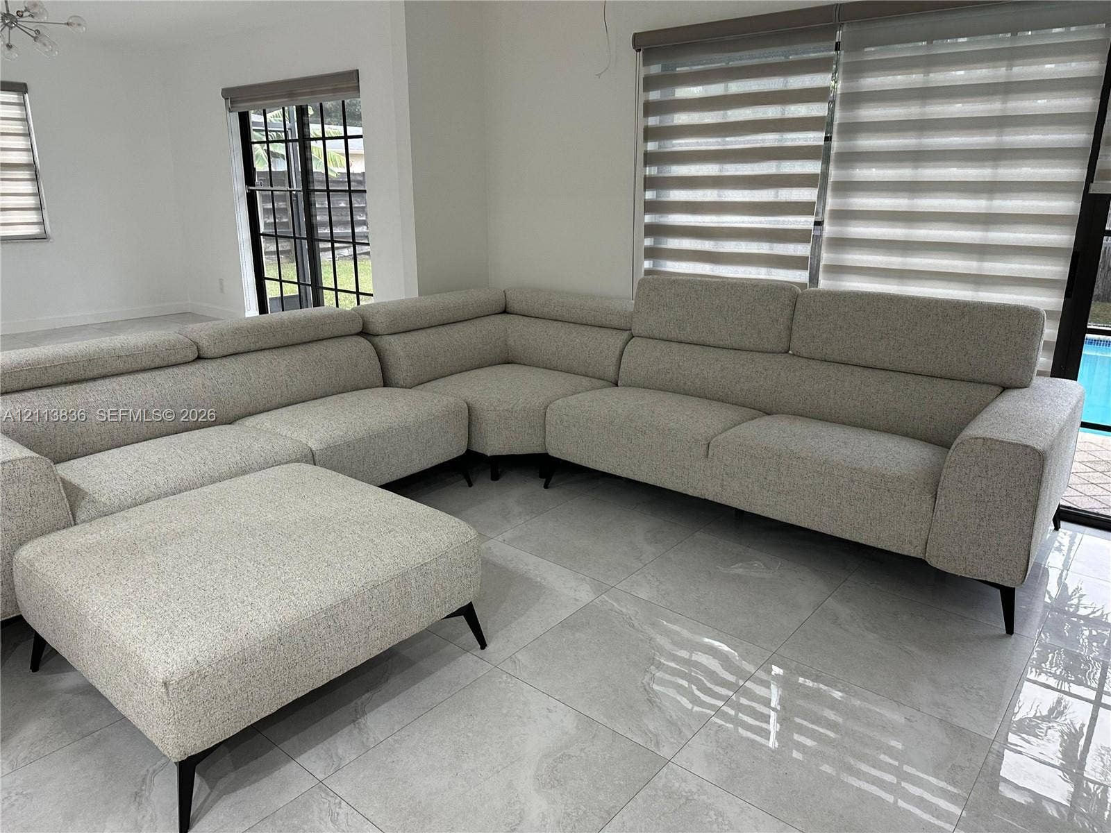 10153 SW 51st Street, Cooper City, Cooper City, FL 33328 Large-format tile flooring, oversized black-framed sliding glass doors, and dual-layered window treatments