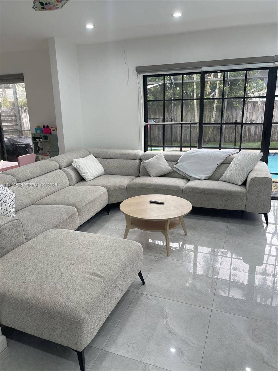 10153 SW 51st Street, Cooper City, Cooper City, FL 33328 Large-format polished tile flooring, black-framed multi-pane sliding glass door, and recessed ceiling lighting