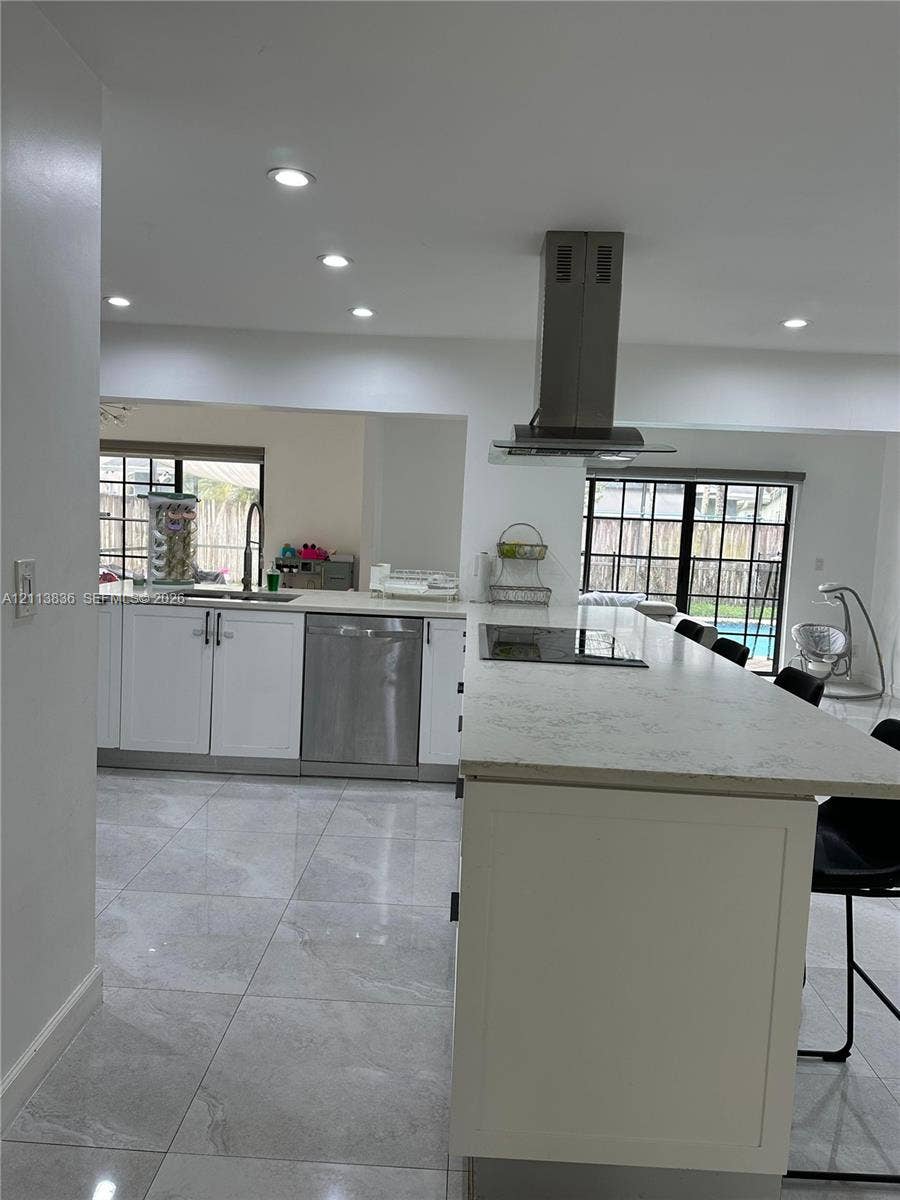 10153 SW 51st Street, Cooper City, Cooper City, FL 33328 Kitchen featuring a large stone-surface island, white cabinetry, stainless steel dishwasher, stainless steel range hood, and recessed lighting