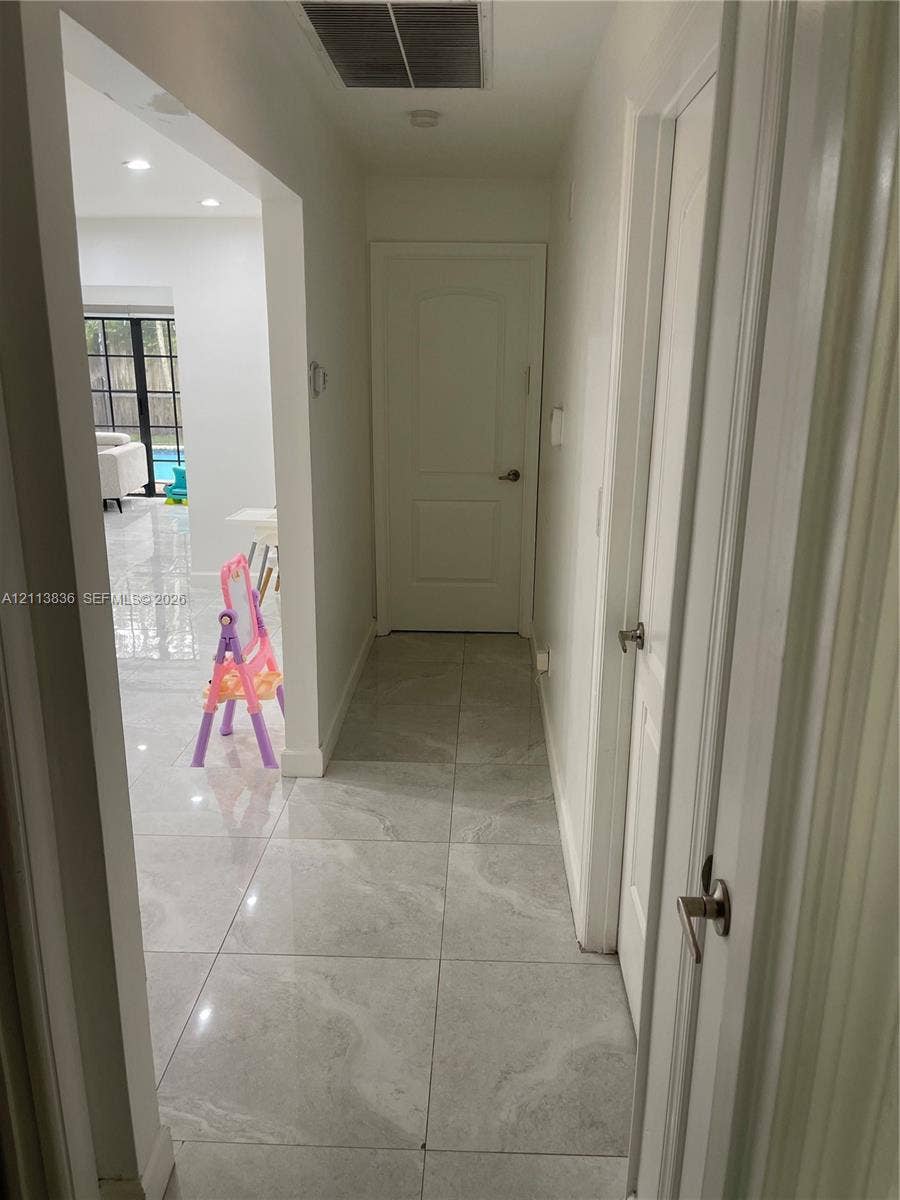 10153 SW 51st Street, Cooper City, Cooper City, FL 33328 Neutral-toned large-format tile flooring, crisp white walls, and interior doors featuring brushed nickel hardware