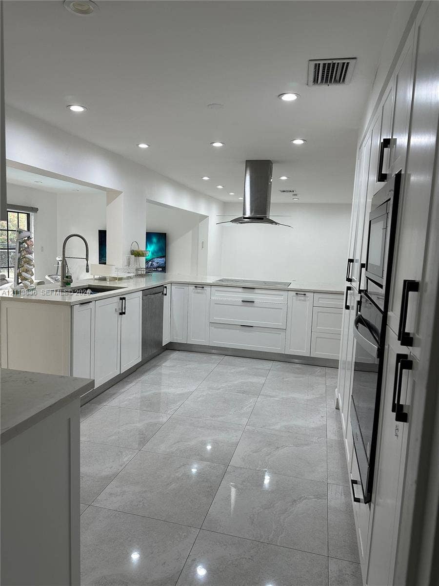 10153 SW 51st Street, Cooper City, Cooper City, FL 33328 Kitchen featuring white shaker cabinetry, stone-finish countertops, stainless steel appliances including a built-in wall oven and range hood, and large-format porcelain tile flooring
