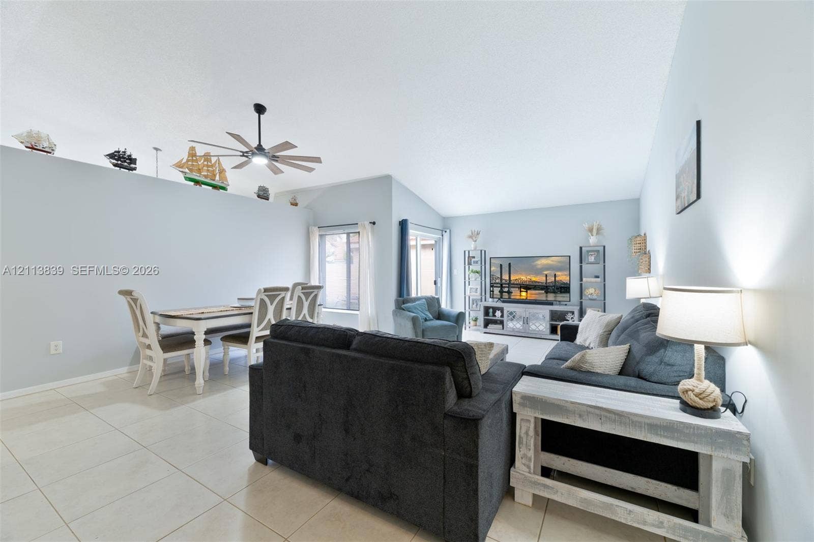 1015 NW 124th Terrace, Sunrise, FL 33323 Vaulted ceilings, large-format tile flooring, ceiling fan, and sliding glass door