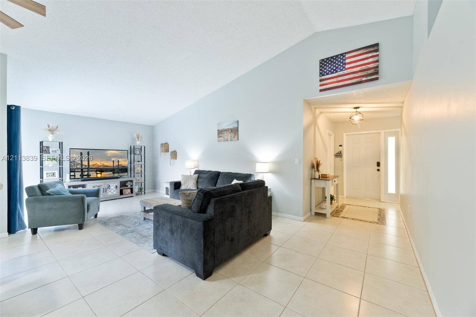 1015 NW 124th Terrace, Sunrise, FL 33323 Vaulted ceilings, neutral ceramic tile flooring, and a glass-paneled entry door