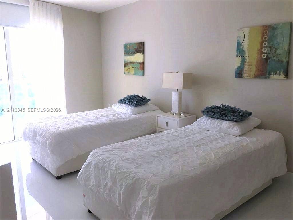 250 Sunny Isles Boulevard, #3-1506, Sunny Isles Beach, Sunny Isles Beach, FL 33160 Neutral-toned interior space featuring light-reflective flooring and floor-to-ceiling glass paneling with integrated window treatments