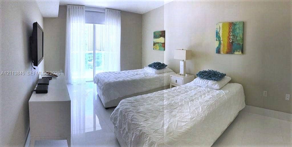 250 Sunny Isles Boulevard, #3-1506, Sunny Isles Beach, Sunny Isles Beach, FL 33160 Neutral-toned walls, reflective tile flooring, and sliding glass door with balcony access