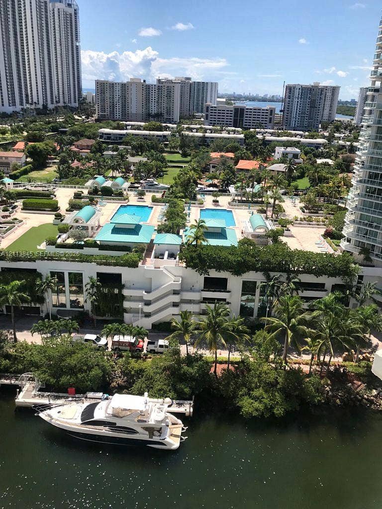 250 Sunny Isles Boulevard, #3-1506, Sunny Isles Beach, Sunny Isles Beach, FL 33160 Aerial perspective featuring dual outdoor swimming pools, landscaped grounds, a boat dock, and waterfront access