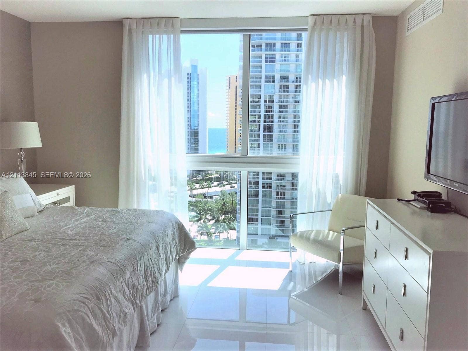 250 Sunny Isles Boulevard, #3-1506, Sunny Isles Beach, Sunny Isles Beach, FL 33160 Floor-to-ceiling windows featuring urban and ocean scenery, high-gloss tile flooring, and neutral wall tones