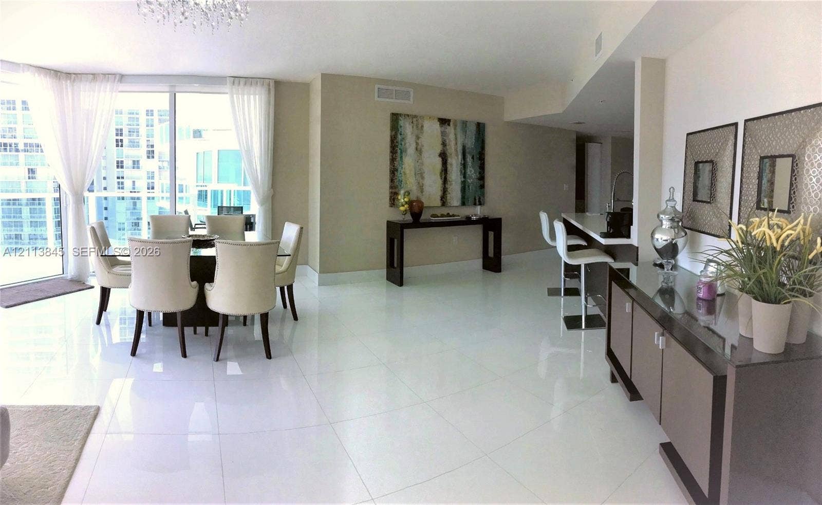 250 Sunny Isles Boulevard, #3-1506, Sunny Isles Beach, Sunny Isles Beach, FL 33160 Open-concept living space featuring high-gloss tile flooring, floor-to-ceiling windows, and a built-in kitchen breakfast bar
