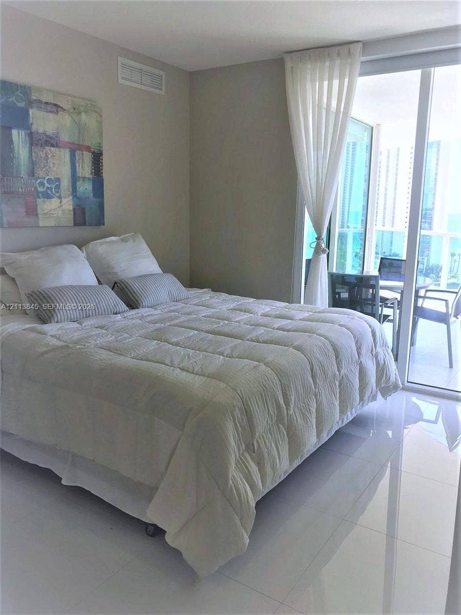 250 Sunny Isles Boulevard, #3-1506, Sunny Isles Beach, Sunny Isles Beach, FL 33160 Polished stone flooring and floor-to-ceiling glass sliding doors opening to a balcony