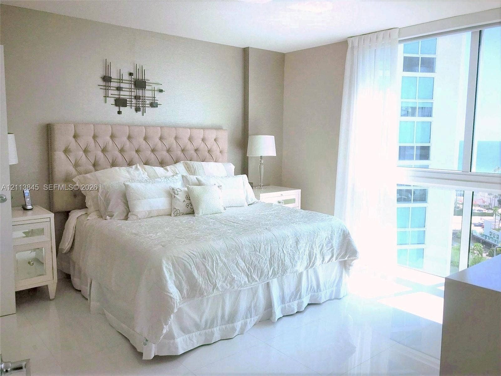 250 Sunny Isles Boulevard, #3-1506, Sunny Isles Beach, Sunny Isles Beach, FL 33160 Floor-to-ceiling windows featuring exterior maritime scenery, paired with polished neutral-toned tile flooring