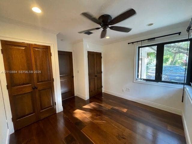 721 Tibidabo Avenue, #0, Coral Gables, Coral Gables, FL 33143 Interior space featuring wood-finish flooring, stained wood double-door closet cabinetry, a multi-pane window with a black frame, and a ceiling-mounted fan
