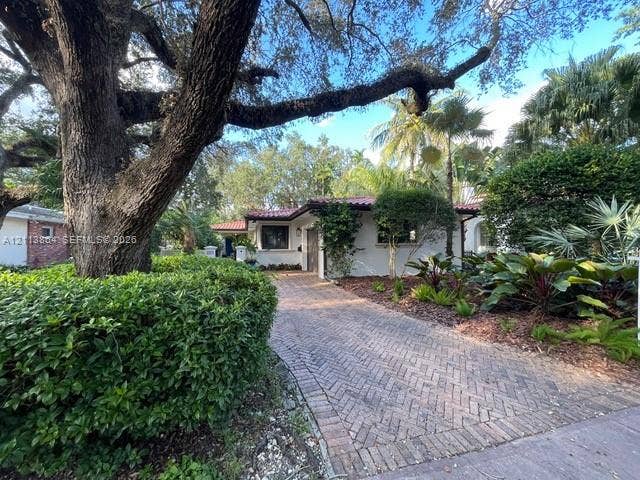 721 Tibidabo Avenue, #0, Coral Gables, Coral Gables, FL 33143 Single-story exterior featuring a red tile roof, herringbone-pattern brick driveway, mature canopy trees, and established tropical landscaping