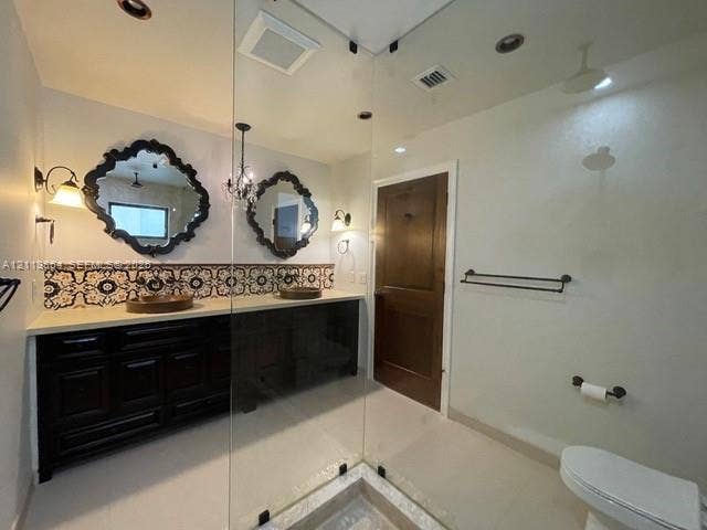 721 Tibidabo Avenue, #0, Coral Gables, Coral Gables, FL 33143 Dark wood dual vanity with light stone countertop, patterned ceramic tile backsplash, two decorative wall mirrors, and glass-enclosed shower