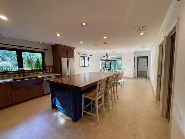 721 Tibidabo Avenue, #0, Coral Gables, Coral Gables, FL 33143 Kitchen featuring an expansive center island with a wood countertop, custom cabinetry, farmhouse sink, stone-finish tile flooring, and recessed lighting