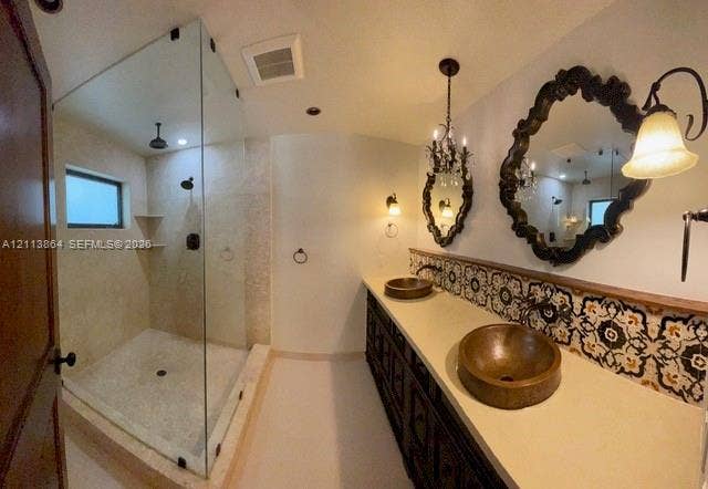 721 Tibidabo Avenue, #0, Coral Gables, Coral Gables, FL 33143 Double vanity featuring dual hammered metal vessel sinks, patterned tile backsplash, glass-enclosed walk-in shower with stone-finish surround, and decorative wall-mounted light fixtures