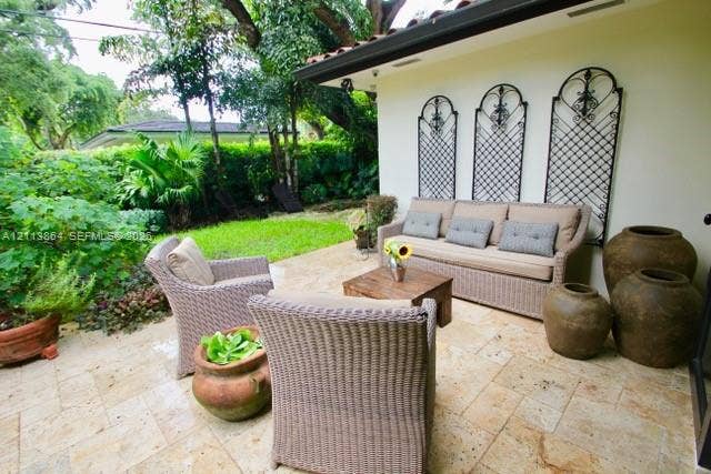 721 Tibidabo Avenue, #0, Coral Gables, Coral Gables, FL 33143 Covered patio featuring stone-tile flooring, decorative metal wall grilles, and landscaping