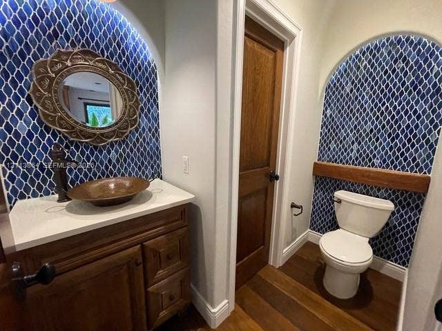 721 Tibidabo Avenue, #0, Coral Gables, Coral Gables, FL 33143 Custom vanity with stone countertop and copper vessel sink, arched alcoves with blue patterned tile work, wood-finish flooring, and solid wood interior door