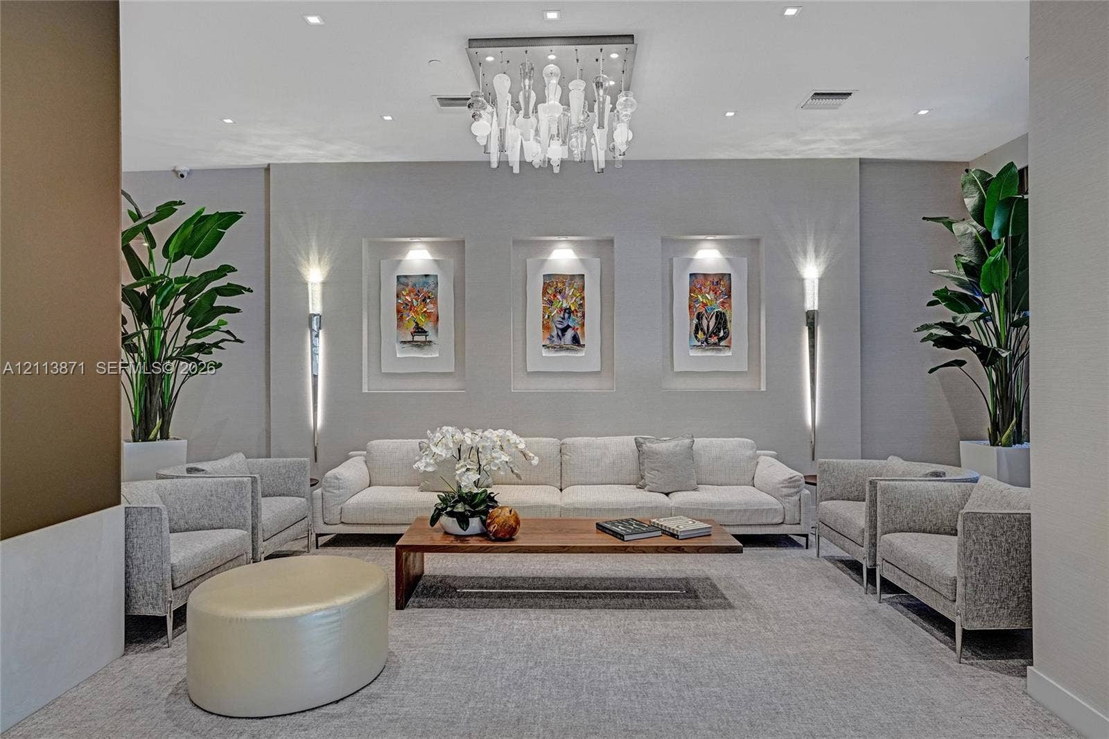 3640 Yacht Club Drive, #1208, Aventura, FL 33180 Artistic chandelier with hanging glass elements, recessed wall niches with integrated lighting, and dual wall-mounted light fixtures